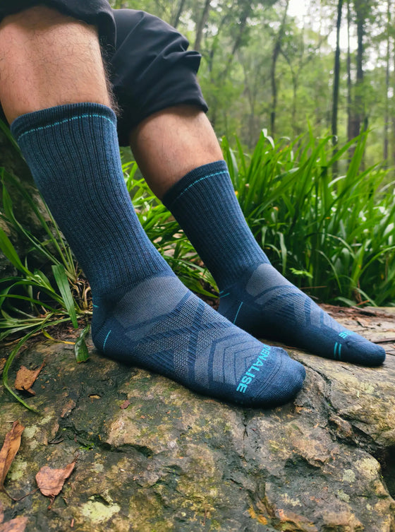 Ribbed navy DENALISE crew socks shown on a mossy woodland rock